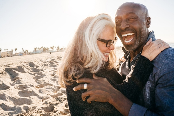 Senior couple laughing on the beach in retirement